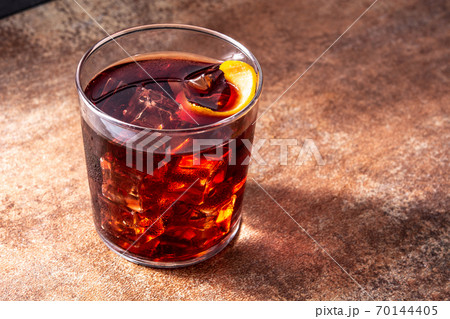 Boulevardier cocktail and orange zest on rusty background.Copy space Boulevardier cocktail and orange zest on rusty background.Copy space 70144405