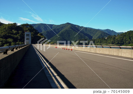 夏の奥多摩湖 堤頂の道路と背景の青空の南岸の山々 夏の奥多摩湖 堤頂の道路と背景の青空の南岸の山々 70145009