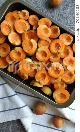 Lot of orange sweet apricots in baking sheet on kitchen towel, selective focus Lot of orange sweet apricots in baking sheet on kitchen towel, selective focus 70146382