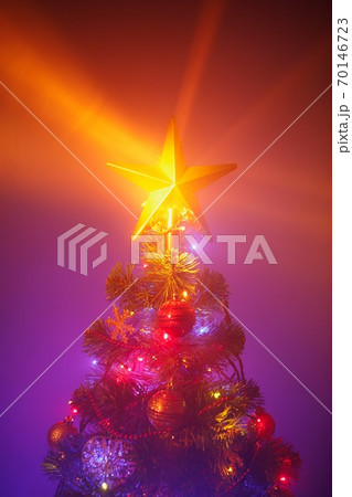 Christmas tree with festive lights, purple background with mist Christmas tree with festive lights, purple background with mist 70146723