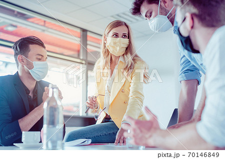 Business team negotiating an agreement wearing face masks Business team negotiating an agreement wearing face masks 70146849