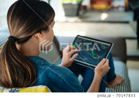 Woman Trading Online Using Tablet Computer On Sofa Woman Trading Online Using Tablet Computer On Sofa 70147833