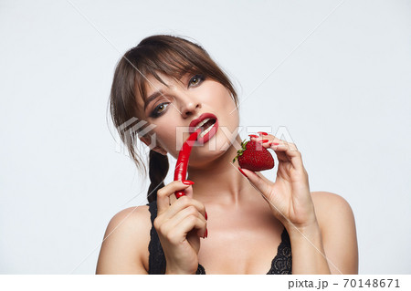 beautiful girl posing with red chili peppers. Studio, White background beautiful girl posing with red chili peppers. Studio, White background 70148671