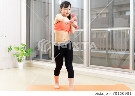 マンション室内で運動する筋トレ女子 ダンベル ダイエット スポーツ ポニーテールの写真素材