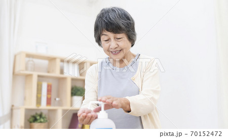 アルコール消毒をするシニア女性 70152472