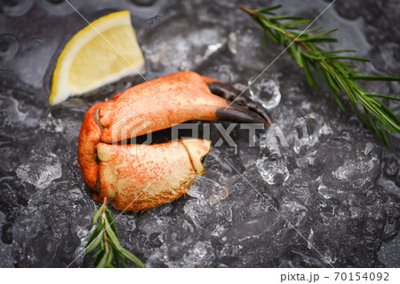 Seafood frozen boiled crab claws Fresh crab with ingredients lemon rosemary on ice at market Seafood frozen boiled crab claws Fresh crab with ingredients lemon rosemary on ice at market 70154092