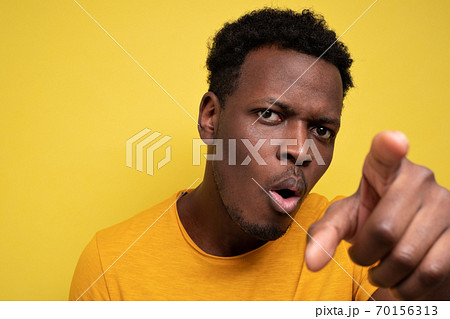 African american guy in yellow casual t-shirt discovering hidden camera African american guy in yellow casual t-shirt discovering hidden camera 70156313