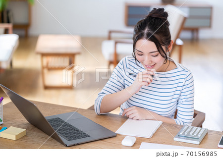 リビングでテレワーク中の若い女性 70156985