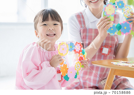 保育イメージ　工作をする女の子と保育士 70158686