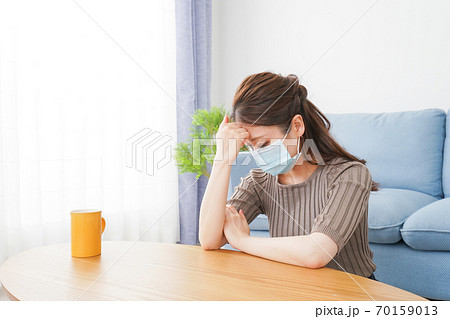 体調不良に苦しむマスクをつけた女性 体調不良に苦しむマスクをつけた女性 70159013