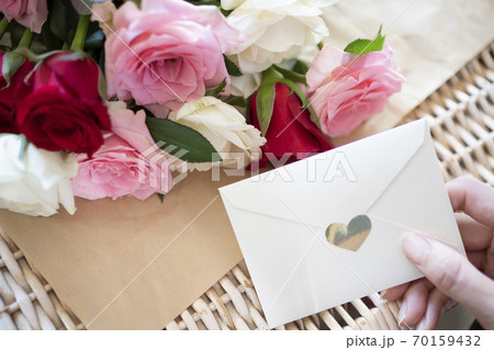 バラの花束とラブレターを持つ女性の手 バラの花束とラブレターを持つ女性の手 70159432