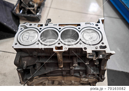 New pistons and cylinder head of engine block vehicle. Motor capital repair. Sixteen valve and four cylinder. Car service concept. The job of a mechanic. Old and new pistons. 70163082