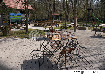 Empty cafe, closed for quarantine. No people. Tables and chairs outside, playground for kids. Empty cafe, closed for quarantine. No people. Tables and chairs outside, playground for kids. 70164066