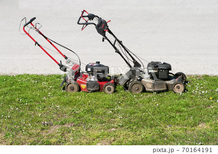 Lawn mowers on green grass, time to cut high grass 70164191