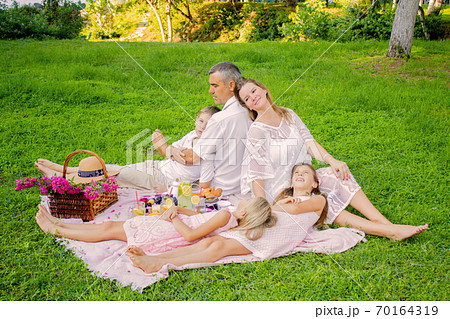 International family having a picnic in the park. 70164319