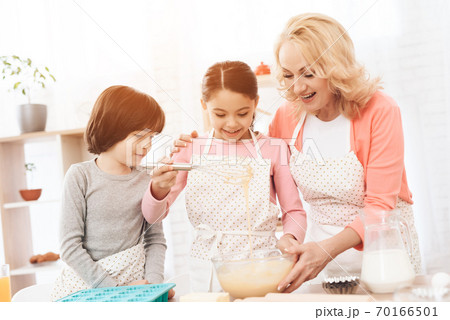 Young granddaughter learning how to cook new dish. Young granddaughter learning how to cook new dish. 70166501