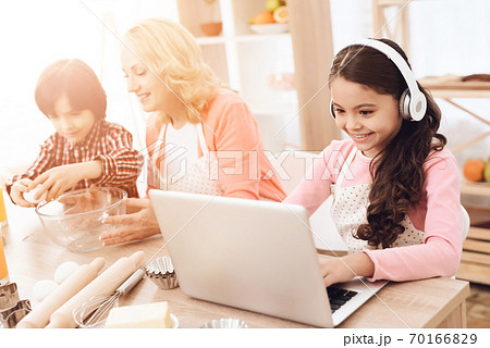 Little girl plays at the computer in headphones. Little girl plays at the computer in headphones. 70166829