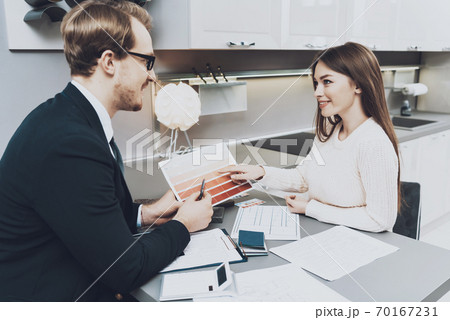 Woman looks at seller and chooses a color. Woman looks at seller and chooses a color. 70167231