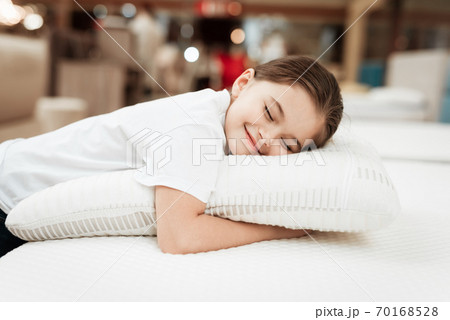 Little girl lies on a pillow and enjoy softness. 70168528