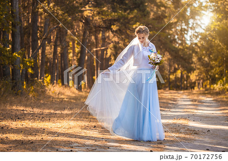 bride with a bouquet is walking the green park 70172756