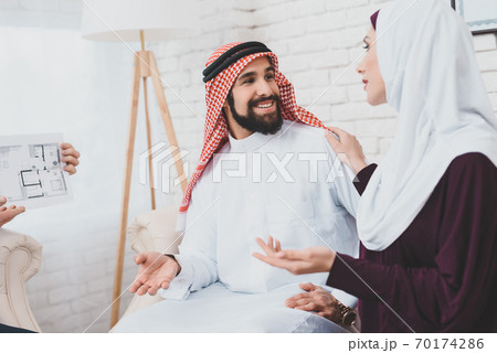 Muslim couple in national dress sitting on sofa. 70174286