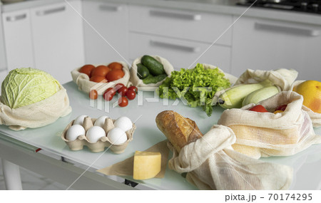 Vegetables, fruits, eggs in reusable eco cotton bags on table. Zero waste shopping concept. Plastic free items. Multi-use, reuse, recycle. Eco friendly canvas grocery bag with tomatoes, pepper, bread. Vegetables, fruits, eggs in reusable eco cotton bags on table. Zero waste shopping concept. Plastic free items. Multi-use, reuse, recycle. Eco friendly canvas grocery bag with tomatoes, pepper, bread. 70174295