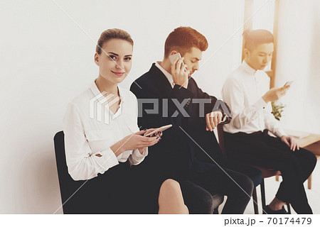 People sit in office and look at their gadgets. People sit in office and look at their gadgets. 70174479