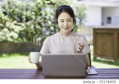 庭でテレワークをする若い女性 70176830