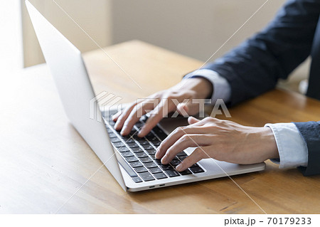 ノートパソコンで作業をする男性の手元 70179233