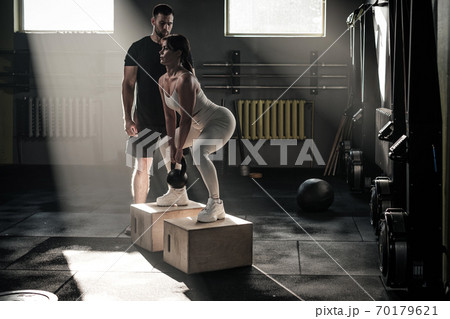 Serious Fitness Lady Do Workout With Trainer . 70179621