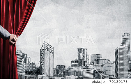 Drawn modern cityscape behind drapery curtain and hand opening it 70180173