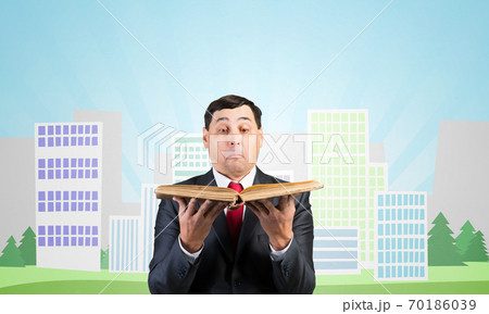Serious businessman holding open book 70186039
