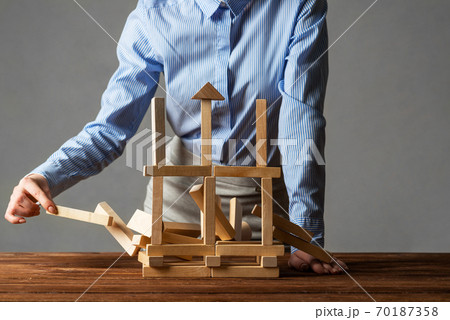 Business woman building tower on table Business woman building tower on table 70187358