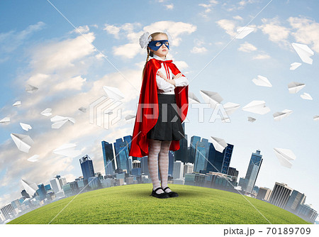 Girl power concept with cute kid guardian against cityscape background 70189709