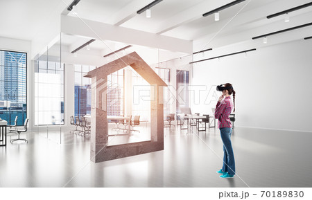 Girl in virtual reality mask experiencing virtual technology world. Mixed media 70189830