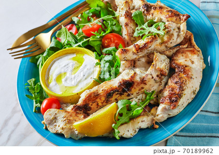 Grilled chicken with arugula salad on a blue plate 70189962