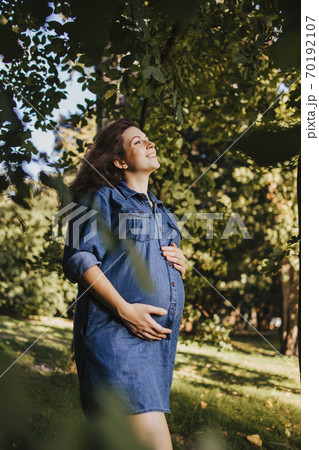 Happy motherhood. Pregnant woman walking outdoors 70192107