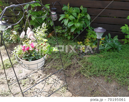 ハンギングした寄せ植えが飾られた庭の写真素材