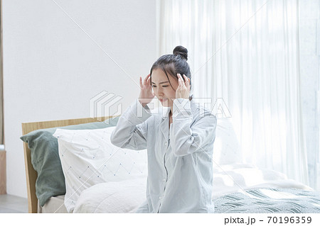 寝起きで体調が悪い女性 70196359