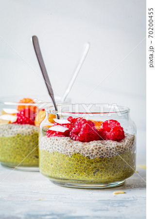 Chia pudding with matcha tea and berries in glass jar, white background. Healthy food concept. 70200455