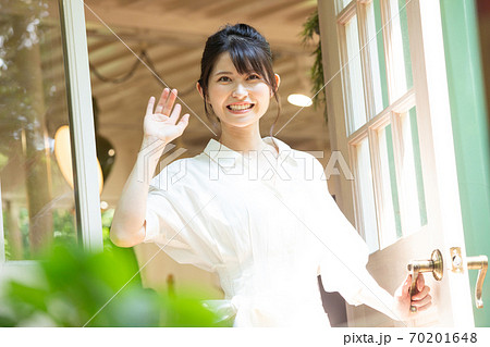 扉を開けて手を振る若い女性　撮影協力：三富今昔村 70201648
