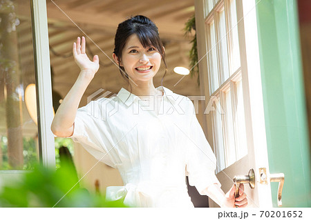 玄関で手を振る若い女性 玄関で手を振る若い女性 70201652