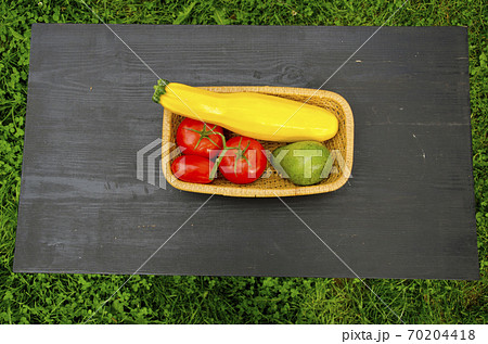 vegetables in wooden plate on black table 70204418
