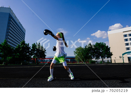 Female child boxer in gloves, feminism concept. Back to school, physical training lesson. 70205219