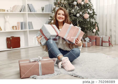 Girl with Christmas gifts in a decorated room Girl with Christmas gifts in a decorated room 70206089