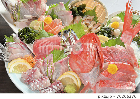 マグロ・金目・イサキ・アジ・サバ・トビウオ・ホタテ・サザエの大皿刺身盛り合わせ（斜め上からアップ） 70206276