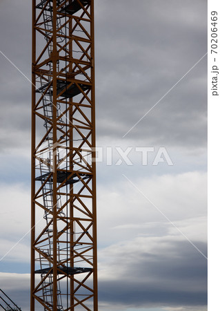 part of a construction crane against a blue sky with clouds, evening  70206469