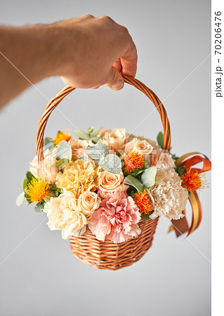 Small flower shop and Flowers delivery. Flower arrangement in Wicker basket. Beautiful bouquet of mixed flowers in woman hand. Handsome fresh bouquet 70206476