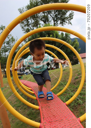 コイル状の遊具の中を歩く子供 コイル状の遊具の中を歩く子供 70207209