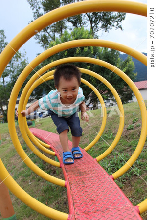 コイル状の遊具の中を歩く子供 コイル状の遊具の中を歩く子供 70207210